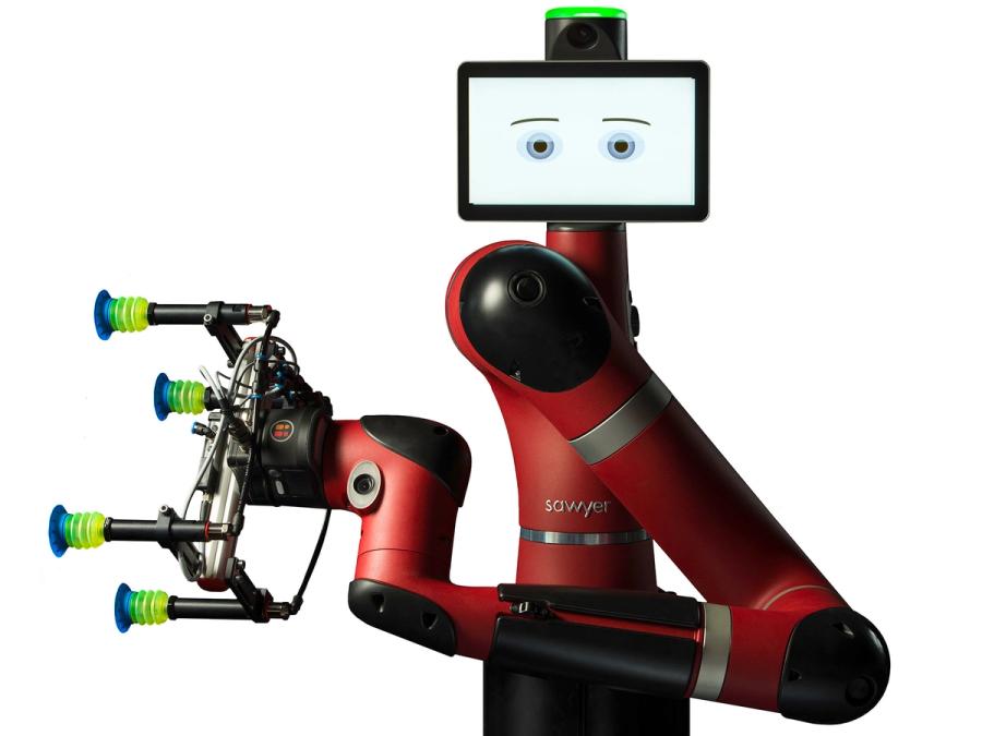 A red industrial one armed robot with an end effector consisting of of four suction cups extending out from a single unit. The robot has a tablet display head showing expressive eyes and eyebrows.
