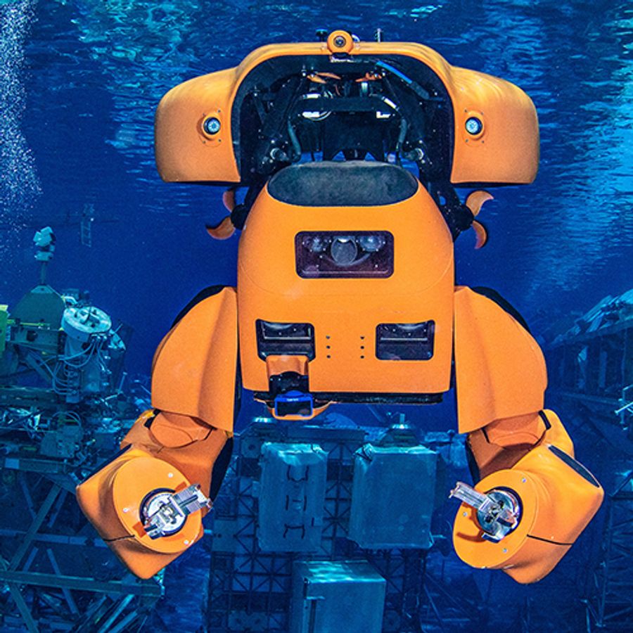 A large orange robot that transforms between sub and humanoid shape is underwater.