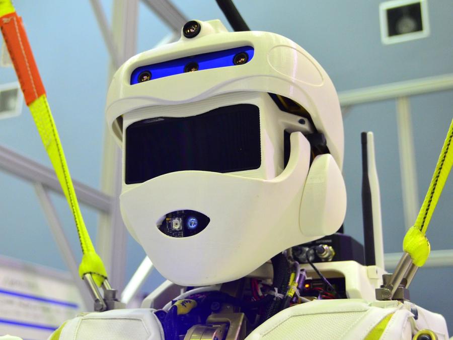 A close-up of Valkyrie's white helmeted head which includes a horizontal forehead panel with sensors, and a mouth section also with visible sensors.