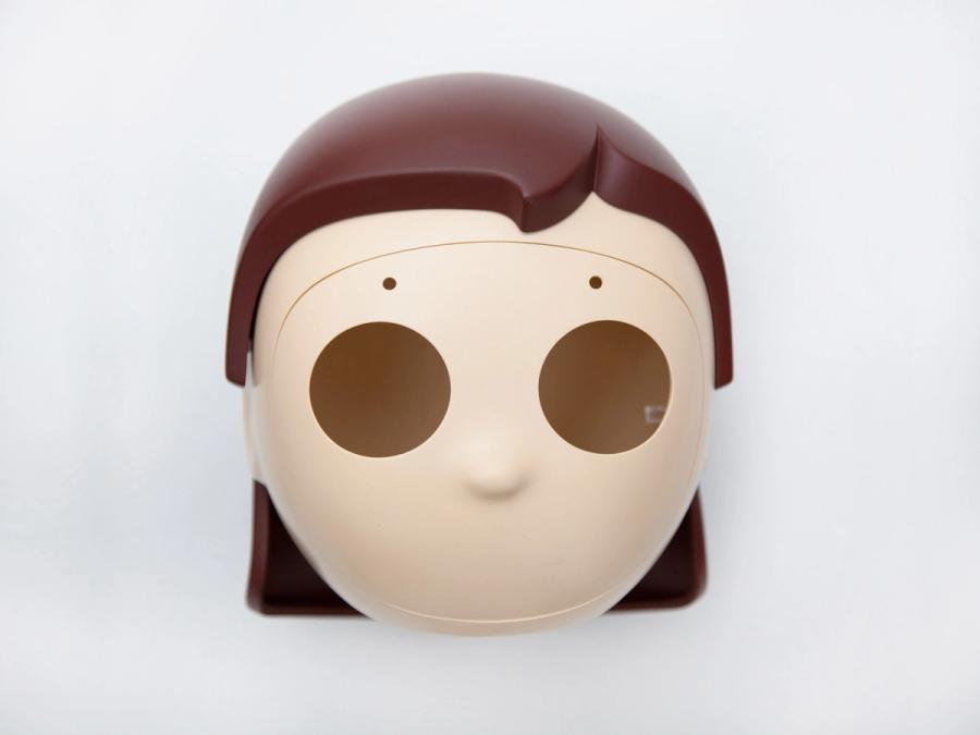 A faceplate with two holes where the eyes will go, and a brown bob haircut. 