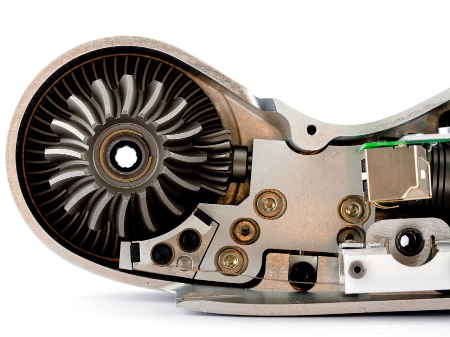 A circular motor is seen inside metal casing.