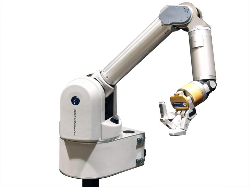 An articulated robot arm extends from a base. It has a gold wrist attached to three fingers, bent and fanned out against a white background.