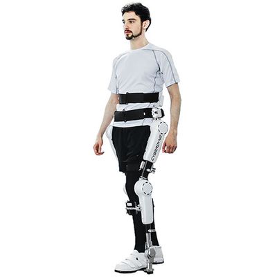 A man poses in a waist down exoskeleton suit that goes down each leg and connects under the foot.