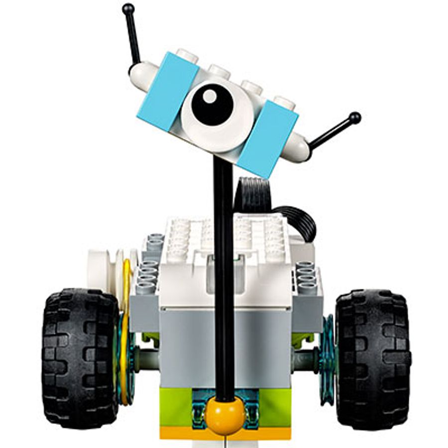 A simple Lego robot with two wheels, a power brick and a cute head with one eye.