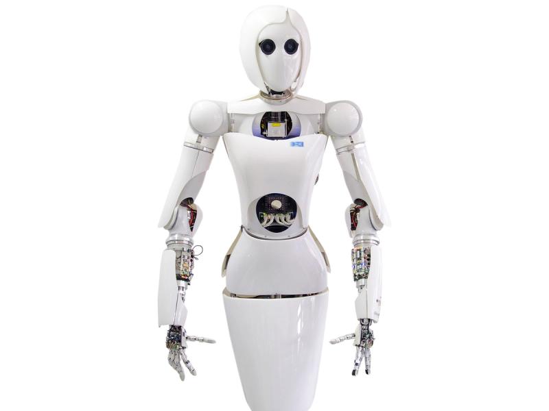 A white humanoid robot with a female appearance including a bob hairdo and the appearance of wearing a dress..
