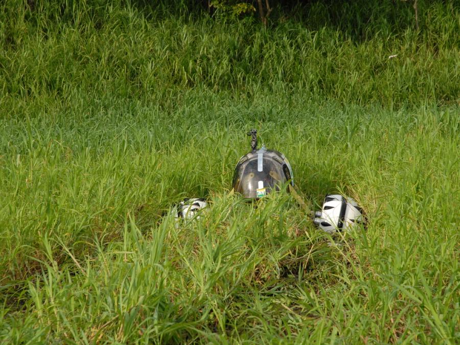 The very top of the robot is seen moving through tall grass.
