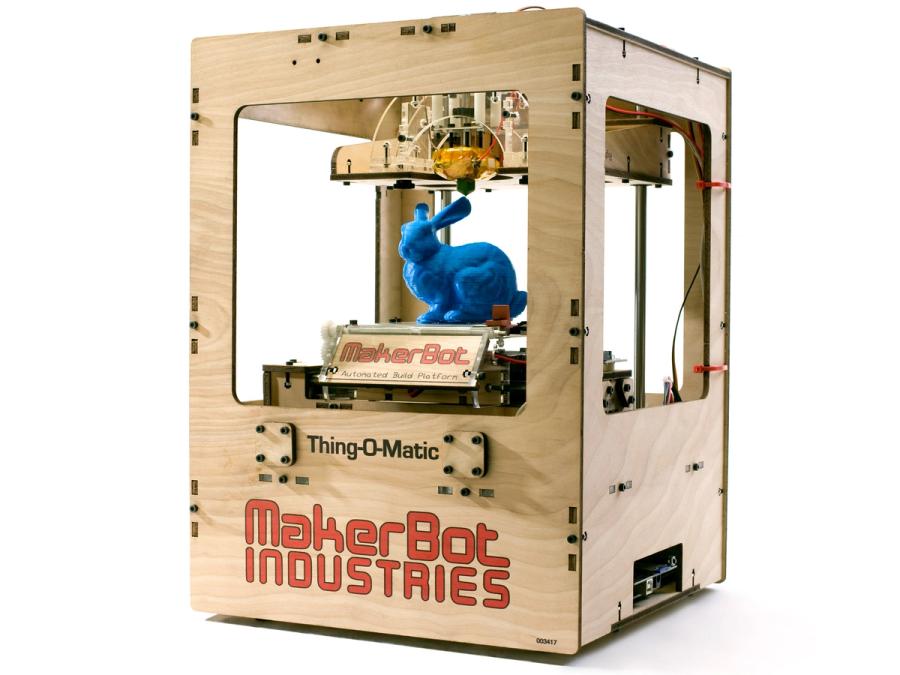 A simple wood box platform labeled MakerBoot Industries holds a blue 3D printed bunny.