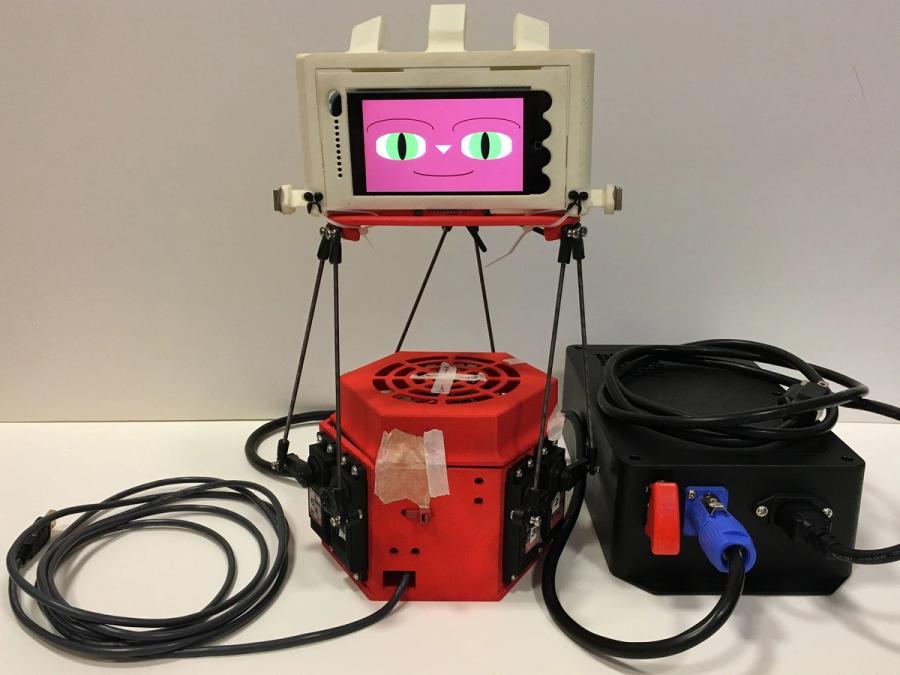 A view inside the robots cute exterior shows a smiling cartoonish face on a display, and a red base with electronics.