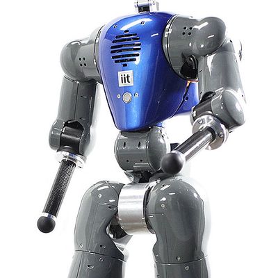A bipedal robot with a blue torso casing and grey arms and legs.