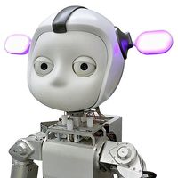 A robot with a round white face, two big eyes, and a helmet-like head shape with two large protruding ears that glow pink. It has a silver torso.