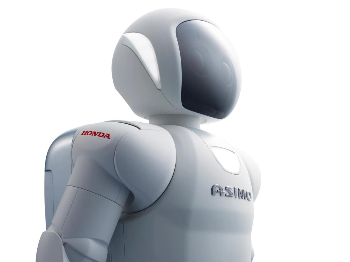 Close up of a Asimo, a white robot with a face shield and backpack.