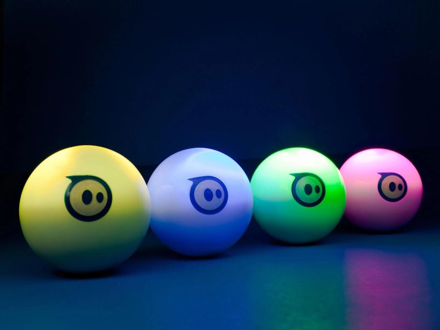 Four balls in a row glow yellow, blue, green and pink. Each has a logo on it like a blue circle with two eyes.