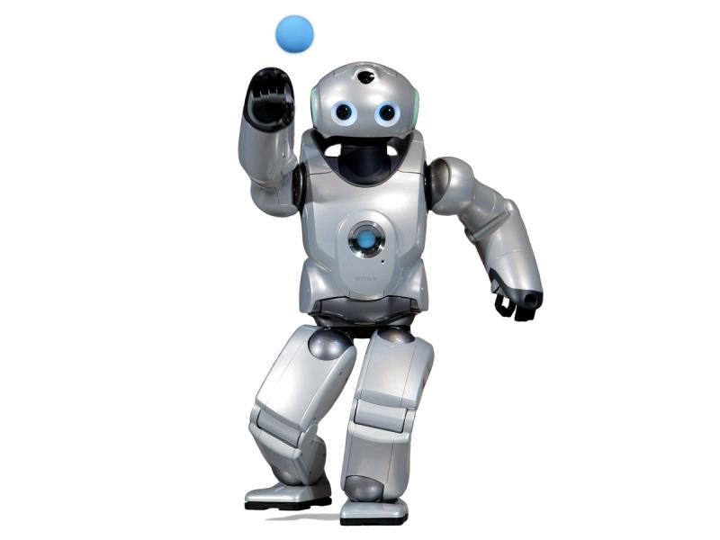 A silver humanoid with two big blue eyes on a rounded head. A small blue ball is being expelled from one of its hands and it stands in an active pitching pose.