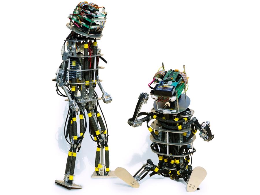Two versions of the toddler robot are seen, one standing and one sitting. 