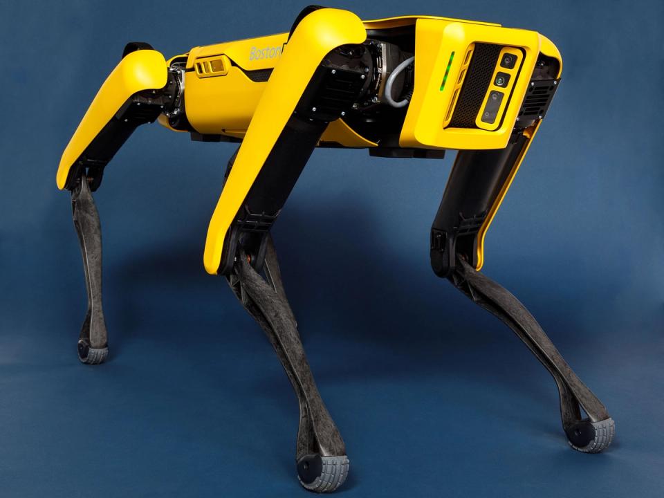 A black and yellow quadruped robot with a face that is a yellow square full of sensors.