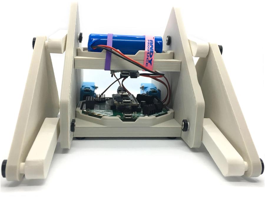 Simple electronics within a structure of 3D printed parts forming an open square base and two triangular flipper feet.