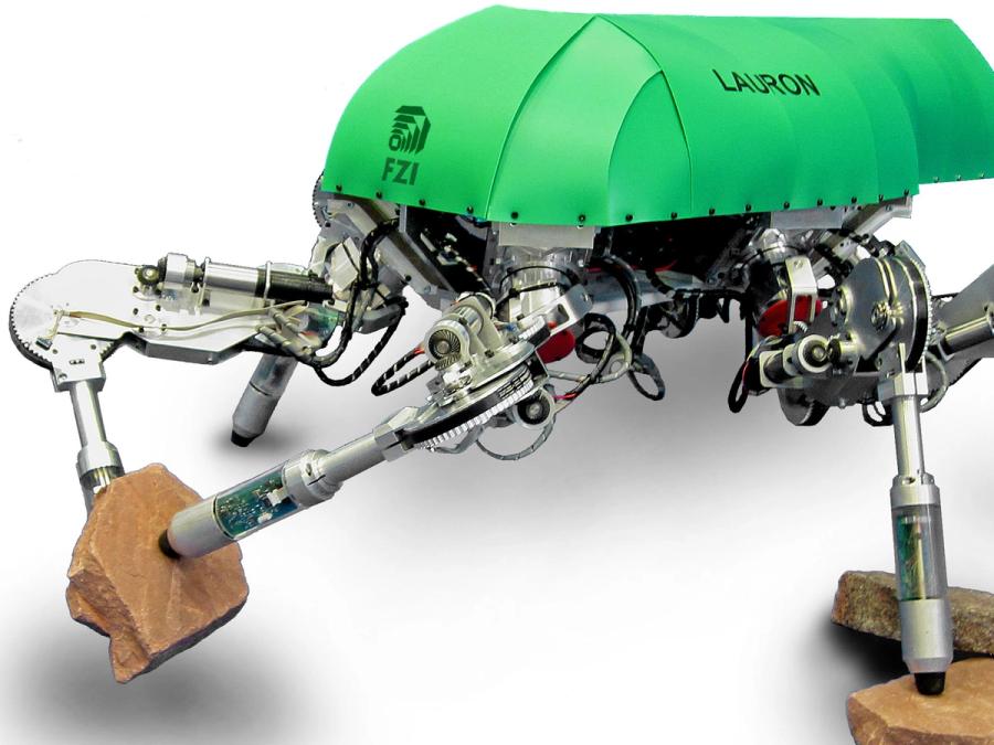 Close-up of two of the robots legs acting as hands, holding a rock tightly between them.