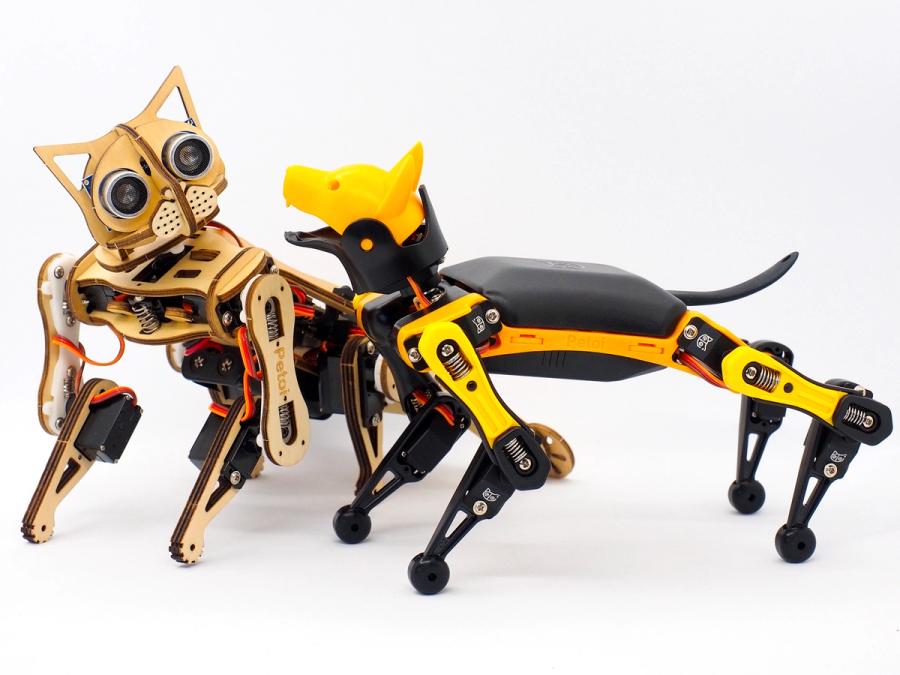 A small robotic cat and dog look at each other