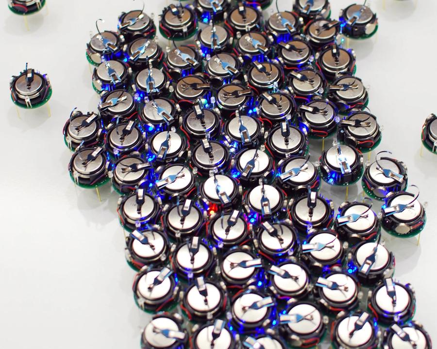 A large group of kilobots pressed together.