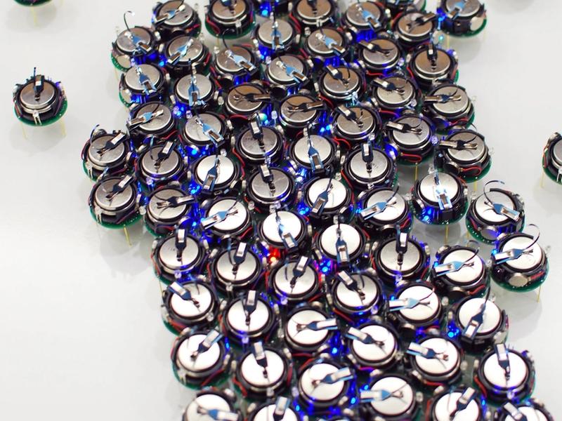 A large group of kilobots pressed together.