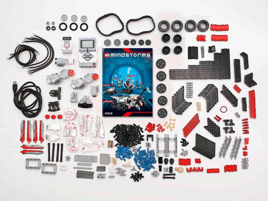 All of the parts that come with Lego Mindstorms are laid out neatly on a table.