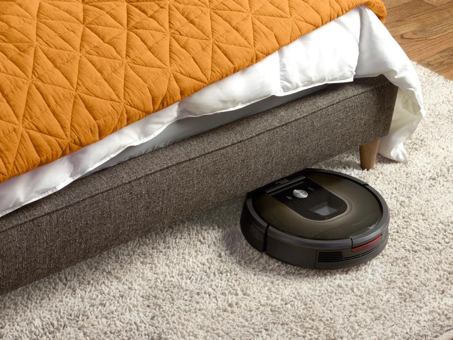 The vacuum is going under a bed.
