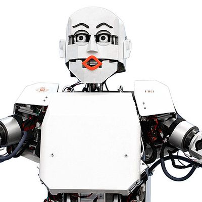 A white-shelled humanoid with an expressive face including pink lips, black eyebrows and eyeballs, controlled by motors.