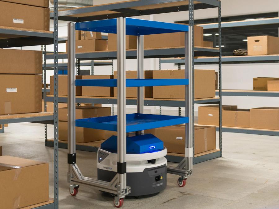 A blue, white and grey mobile robot sits underneath a multi-level cart in a warehouse full of boxes.