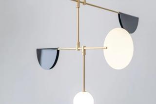 The Phase light, inspired by kinetic mobiles, is a balanced fixture featuring spheres, discs, and semi-circles, with each tier precisely weighted for stability.