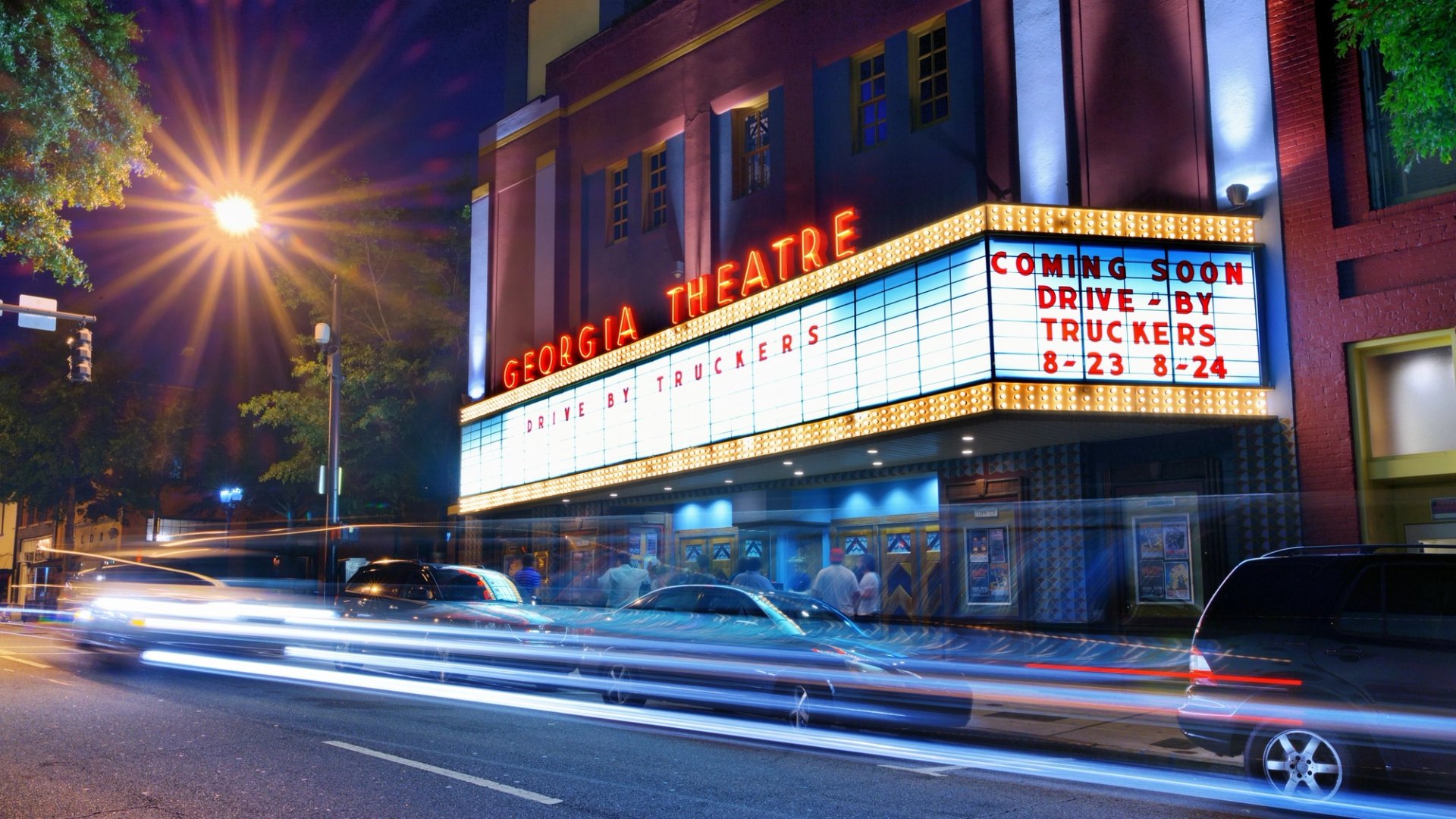 Georgia Theatre's illuminated marquee above passing traffic in downtown Athens at night.