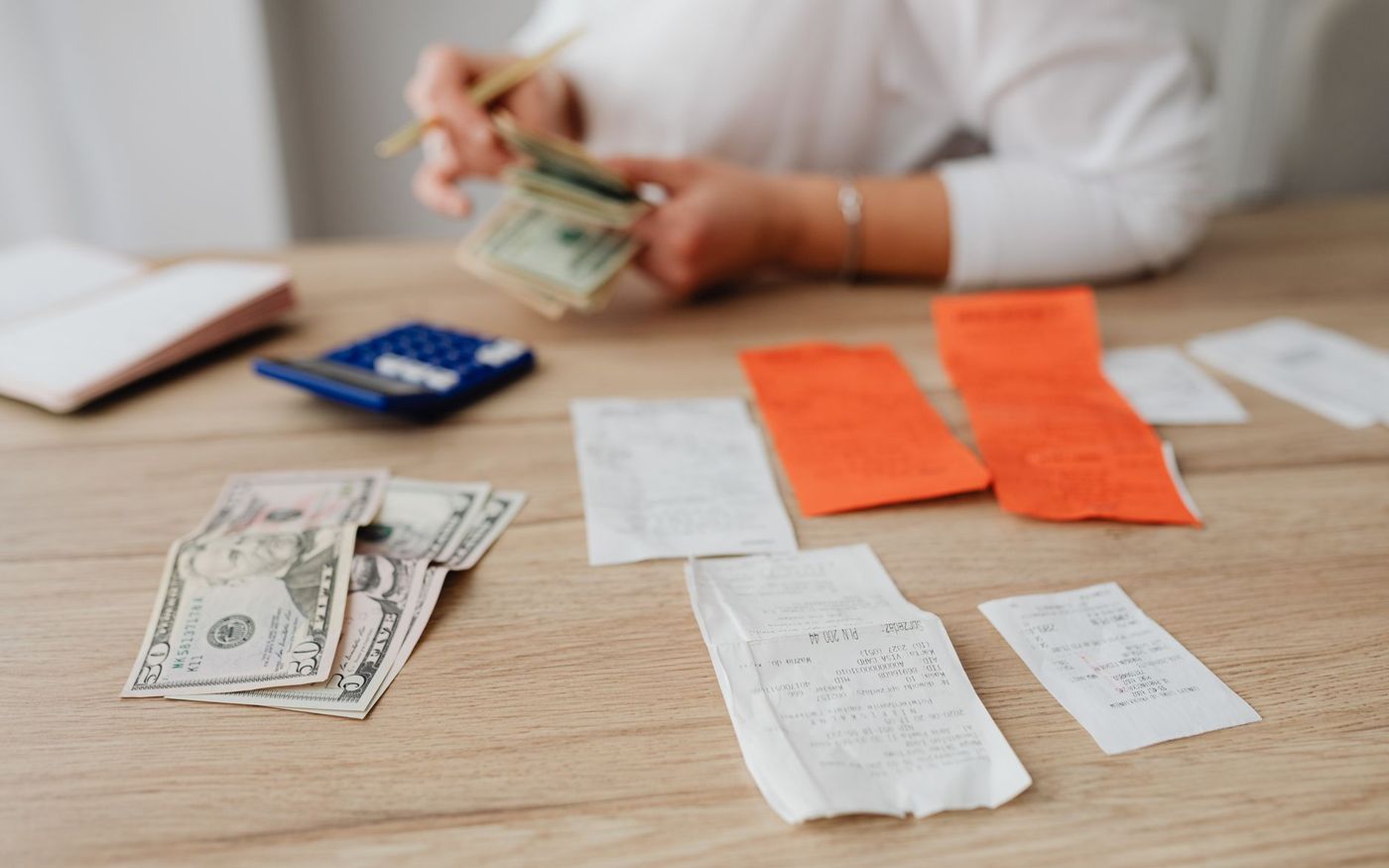 Gestor de restaurante analisa relatórios financeiros em uma mesa do estabelecimento, com a cozinha ao fundo. — Foto: https://kaboompics.com/ (Pexels)