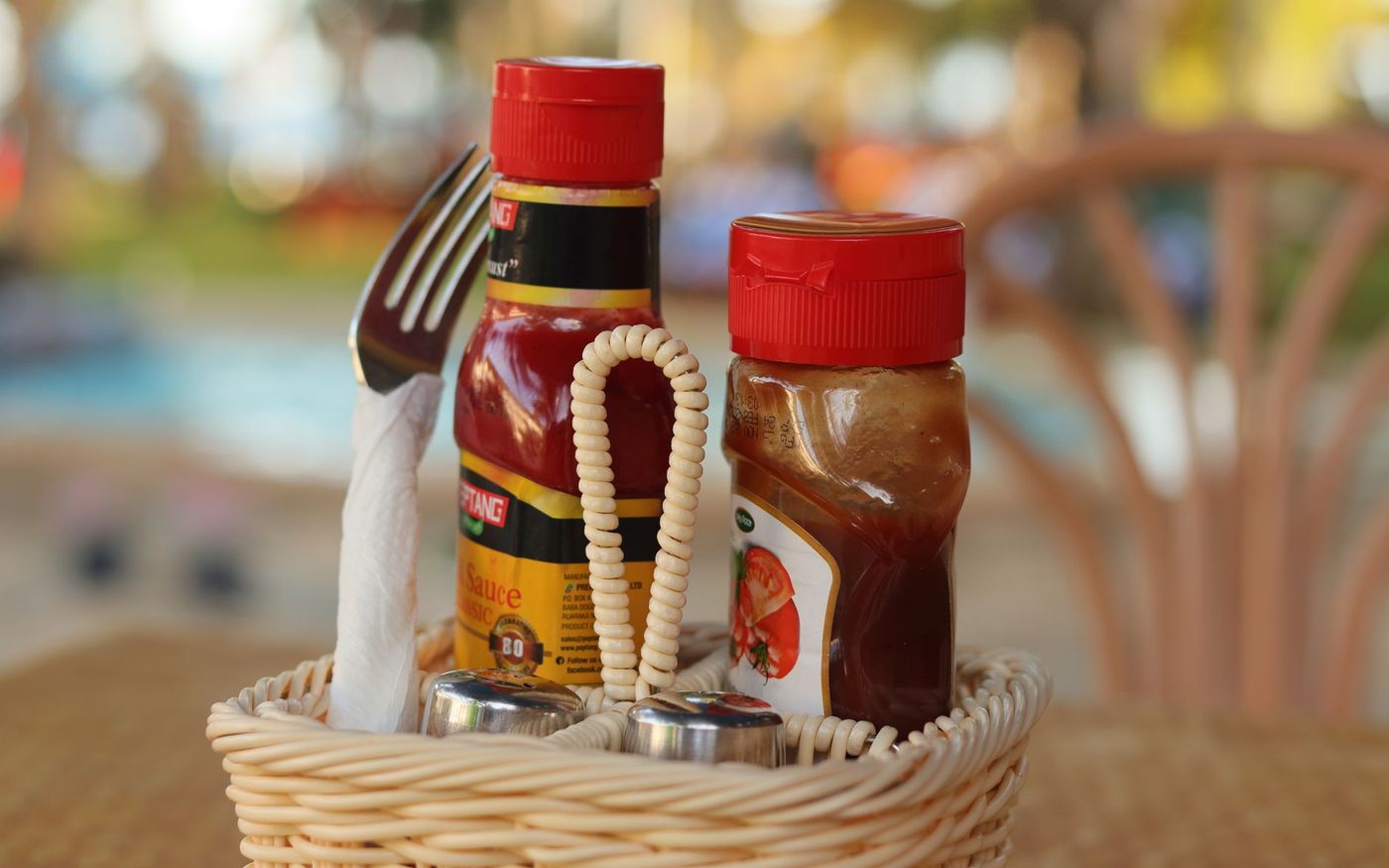 Sachês individuais de condimentos ao lado de um lanche em um balcão de lanchonete. — Foto: Steve Musembi (Pexels)