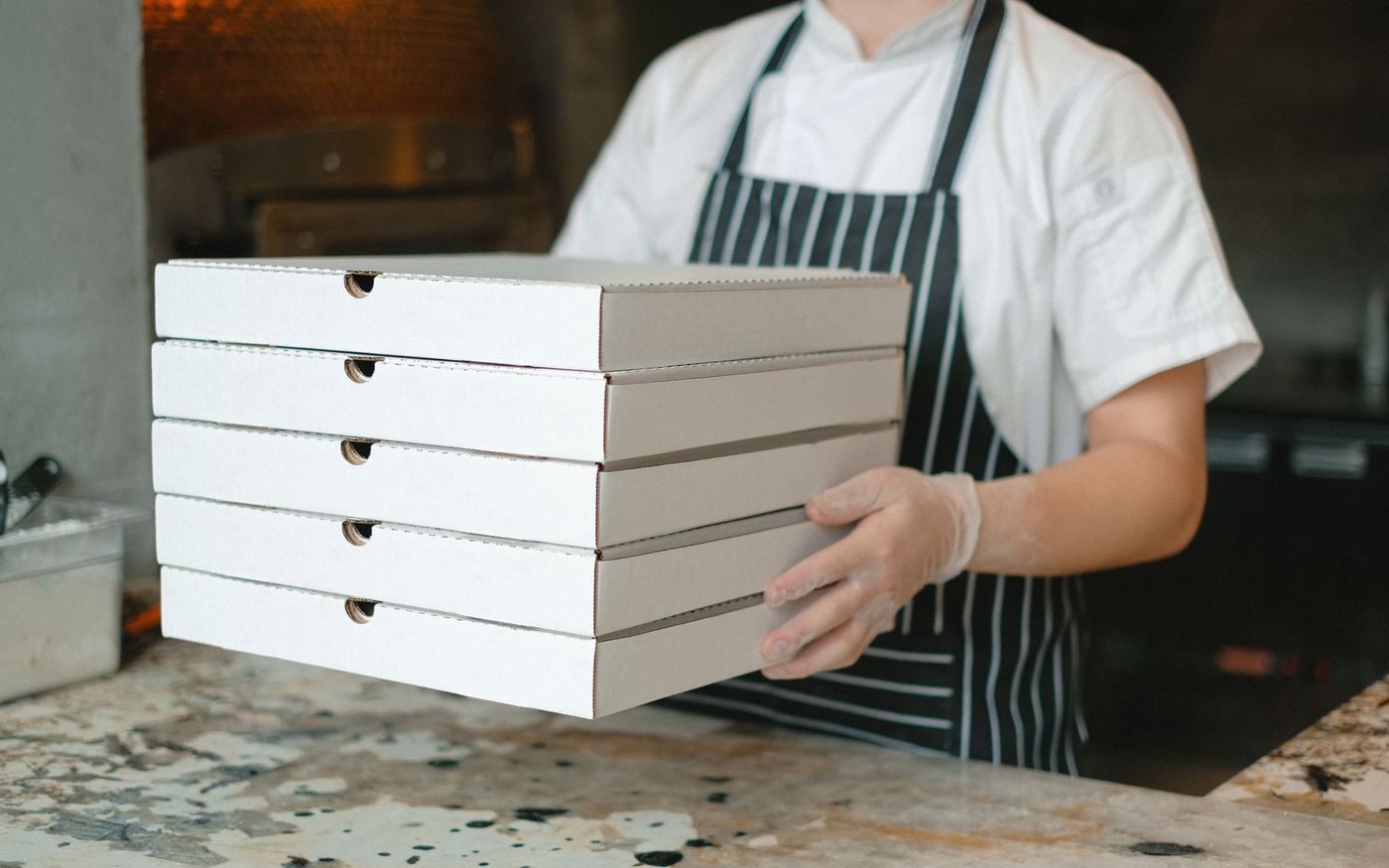 Gestor de restaurante analisa contrato e resultados de vendas por delivery em um balcão. — Foto: Anna Shvets (Pexels)