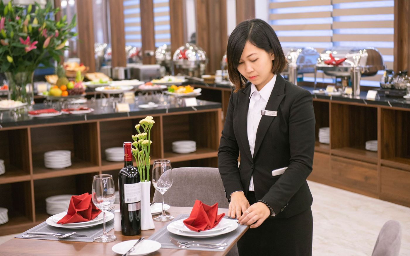 Gestor de restaurante revisa a escala enquanto a equipe se prepara para o serviço. — Foto: Western Skyline Hotel (Pexels)