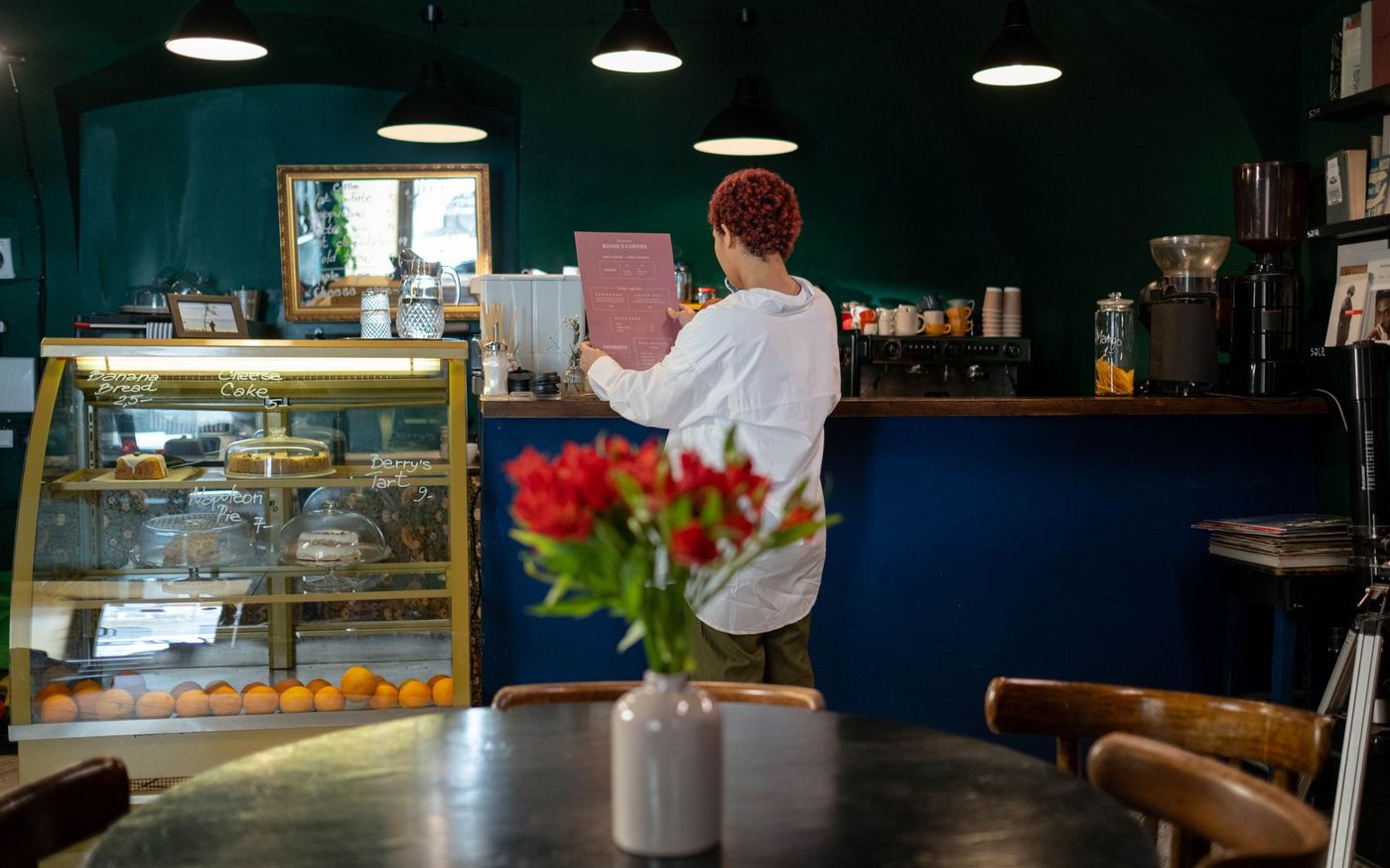 Empresária de restaurante analisa o cardápio e anotações de custos em uma mesa. — Foto: Ron Lach (Pexels)