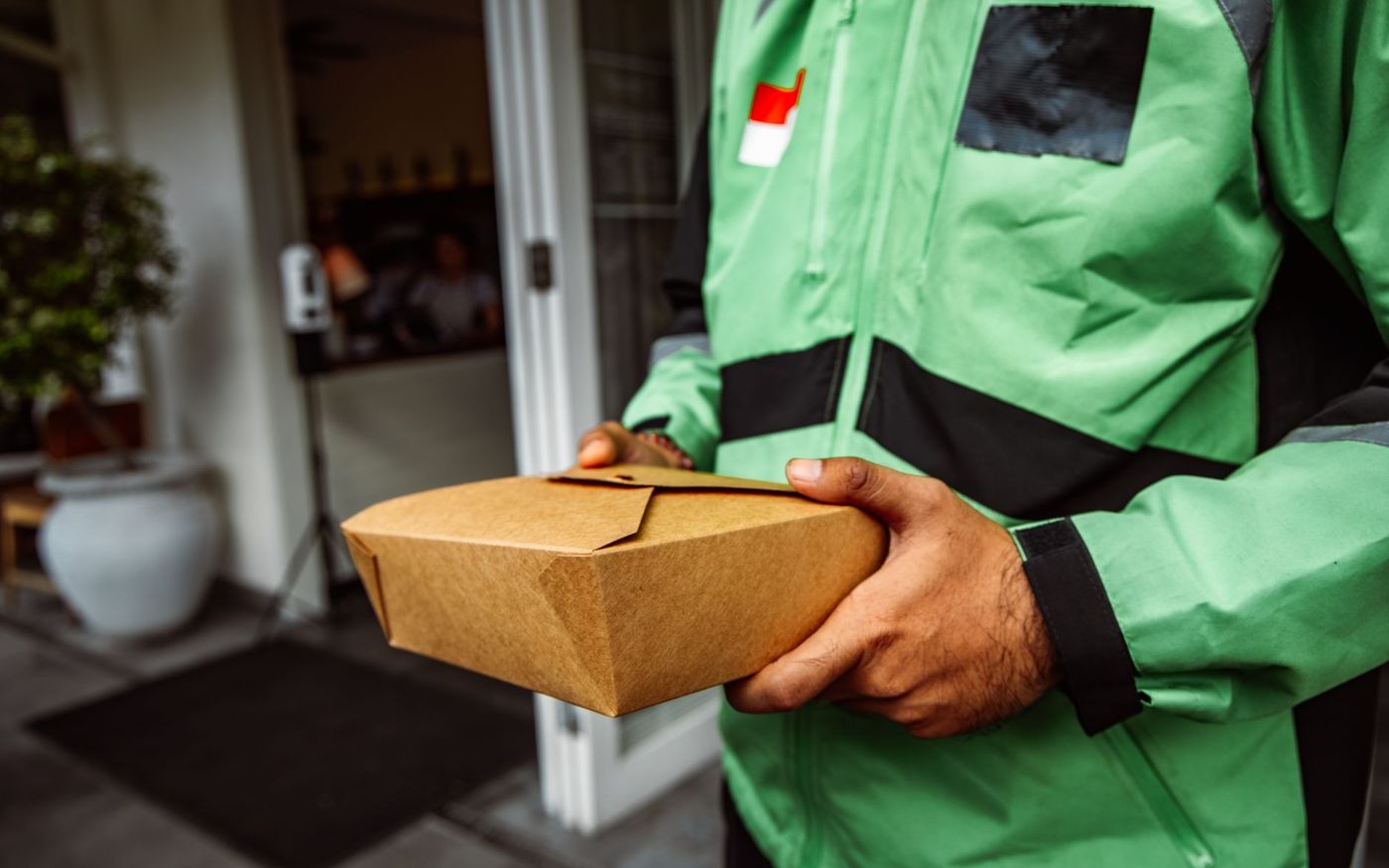 Gestor de restaurante acompanha pedidos em um tablet enquanto um funcionário atende no caixa. — Foto: ROMAN ODINTSOV (Pexels)