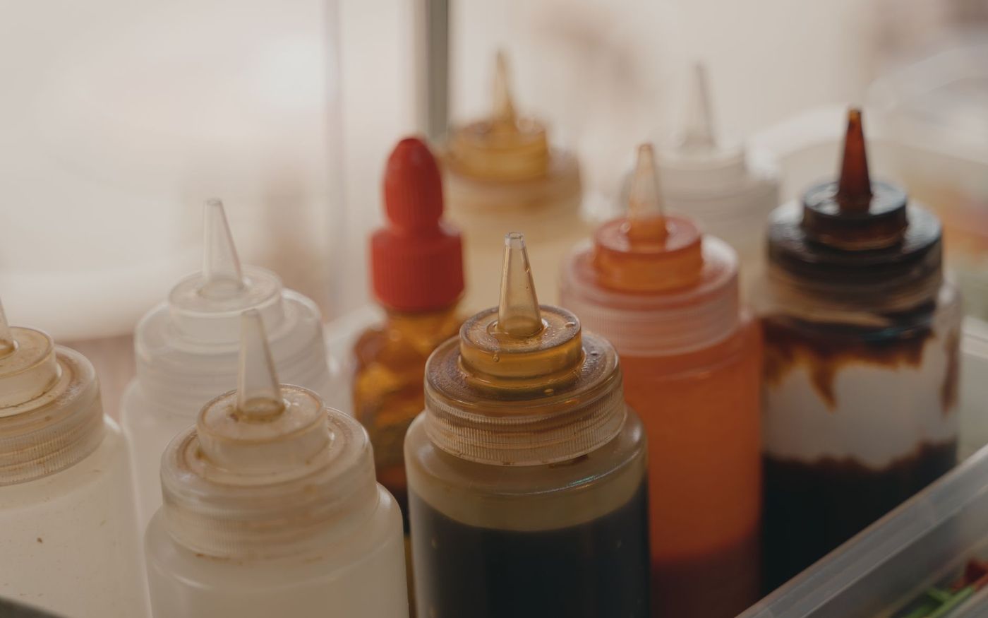 Funcionário de restaurante organiza porções individuais de molho em uma mesa de atendimento. — Foto: Tima Miroshnichenko (Pexels)