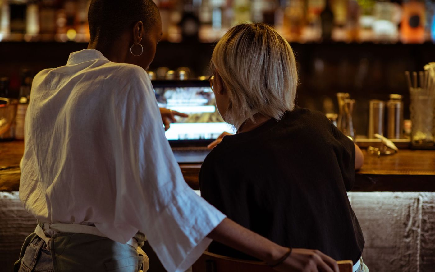 Gestor de restaurante analisa dados de delivery em um laptop, com embalagens de pedidos sobre o balcão. — Foto: Ketut Subiyanto (Pexels)