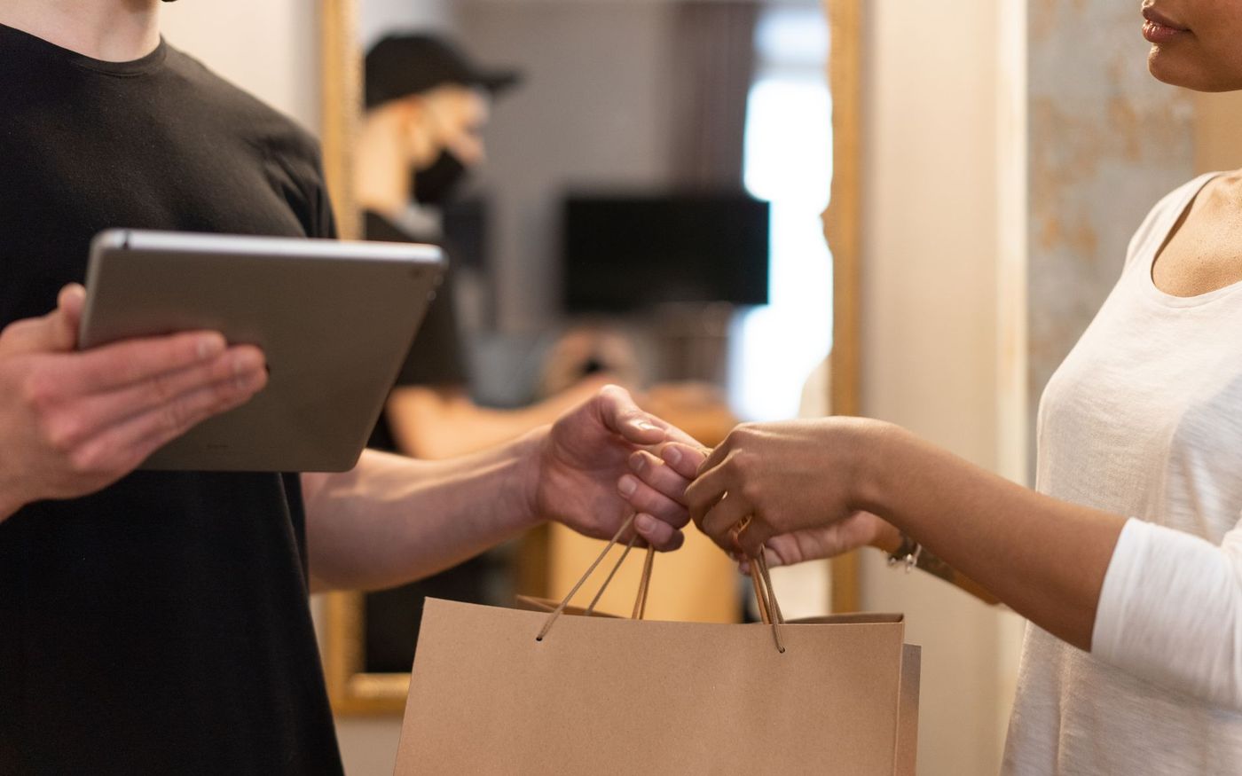 Gestor de restaurante acompanha pedidos de delivery em tablets enquanto a equipe trabalha na cozinha. — Foto: Mikhail Nilov (Pexels)