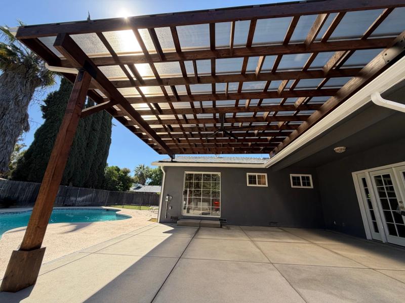 Modern wood patio cover built to provide shade, airflow, and a comfortable outdoor entertainment space.