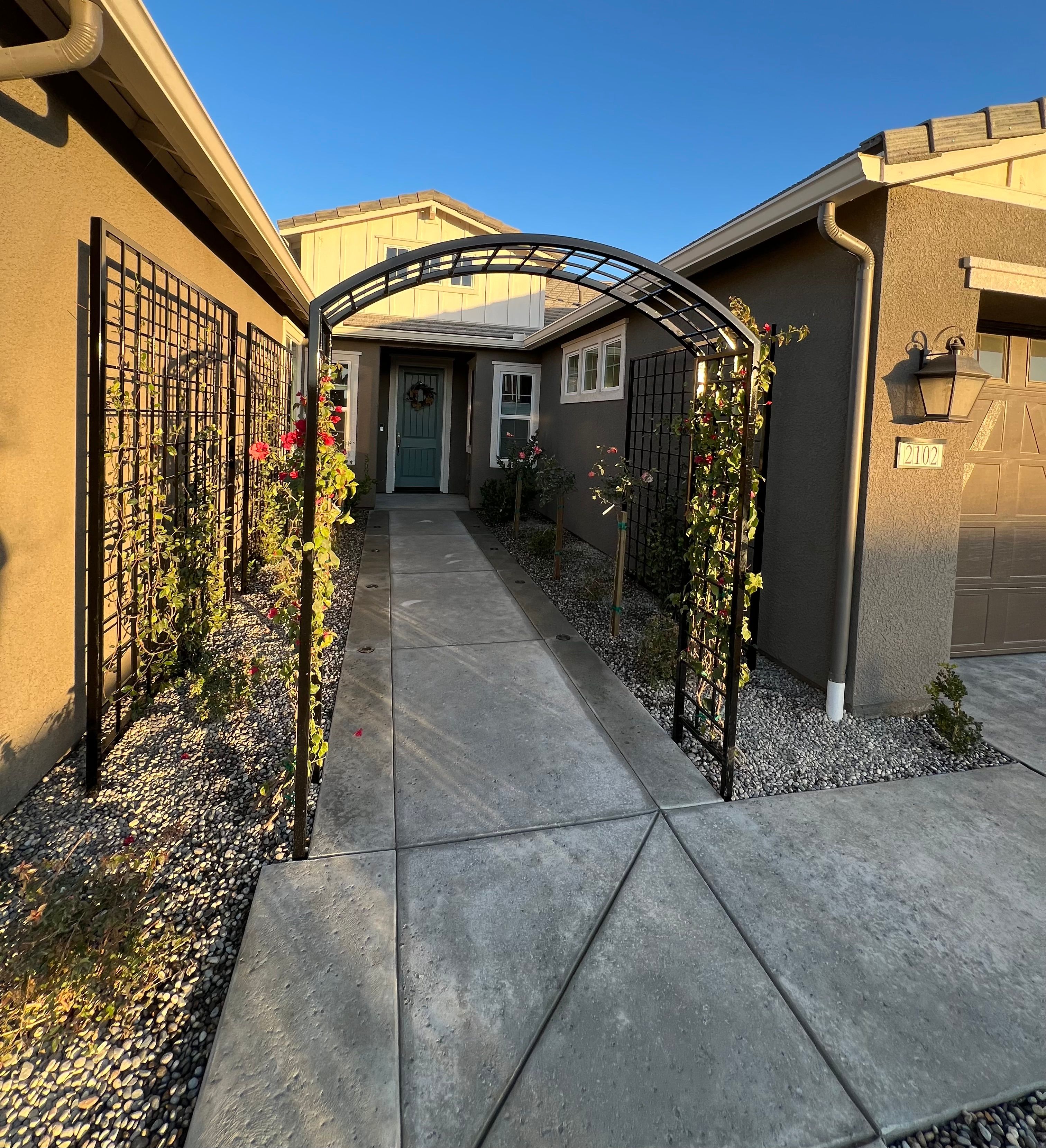 Front entry walkway with with iron arbor and climbing vines