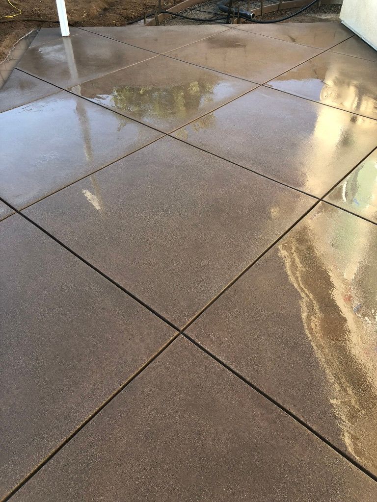 Stained concrete patio with diagonal diamond scoring pattern in gray and brown variegated tones