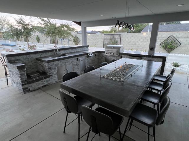 Premium outdoor kitchen with fire pit table and entertainment setup