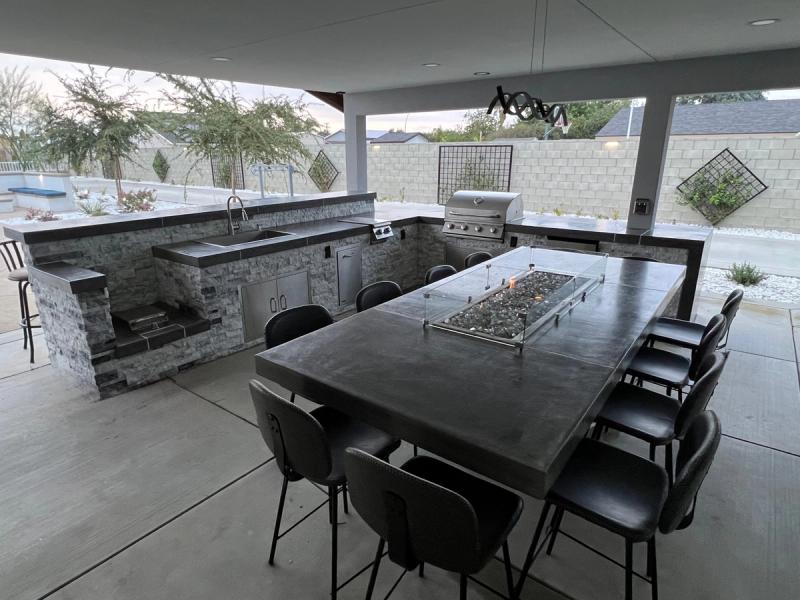 Premium outdoor kitchen with fire pit table and entertainment setup
