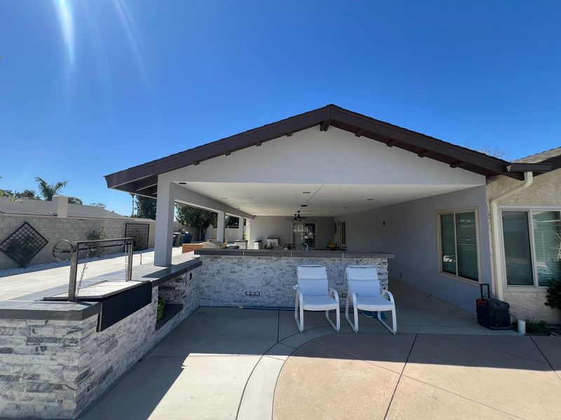 Covered patio with stone bar and outdoor kitchen