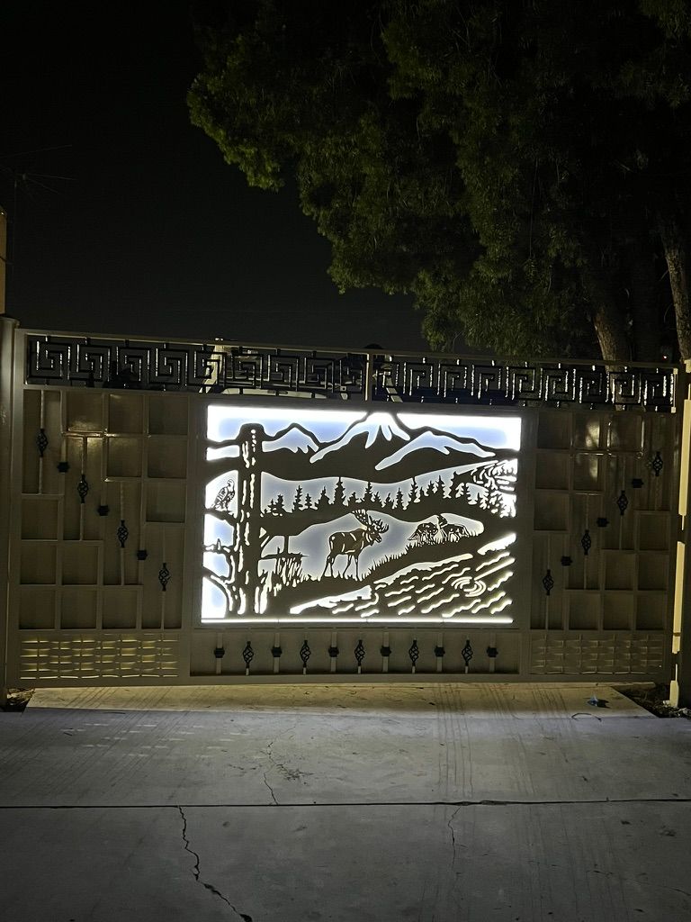 Custom backlit iron driveway gate with mountain elk scene