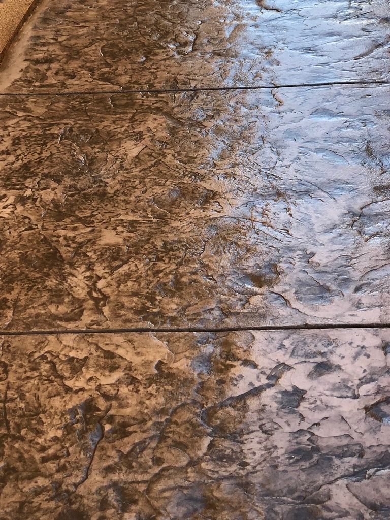Detailed view of acid-stained concrete floor with mottled brown and tan variegated finish and natural color variations