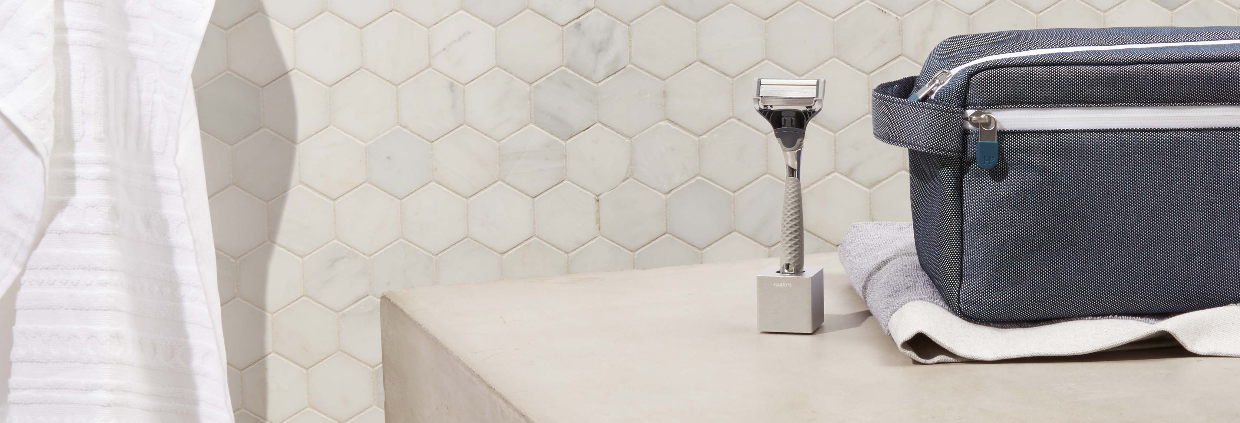 Winston Razor in the Razor Standing sitting next to the Toiletry Bag on bathroom counter.