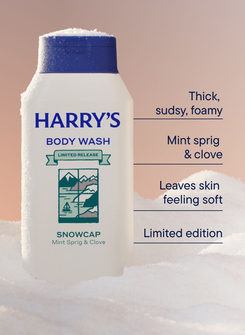 An off white bottle of Snowcap scent body wash in a bank of snow
