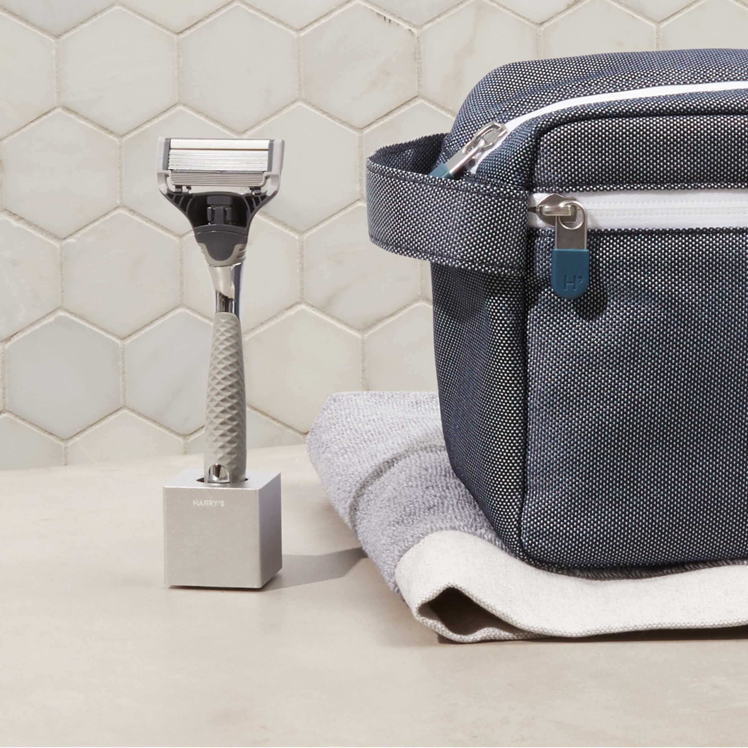 Rasierklingenständer mit Winston-Griff daneben Kulturtasche.